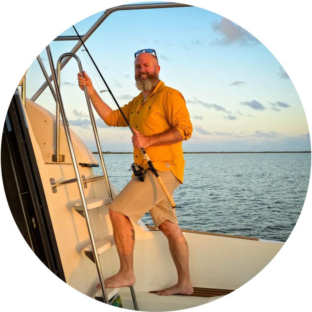 Tom on M/Y Swamp Puppy, climbing to the topside with a fishing rod.