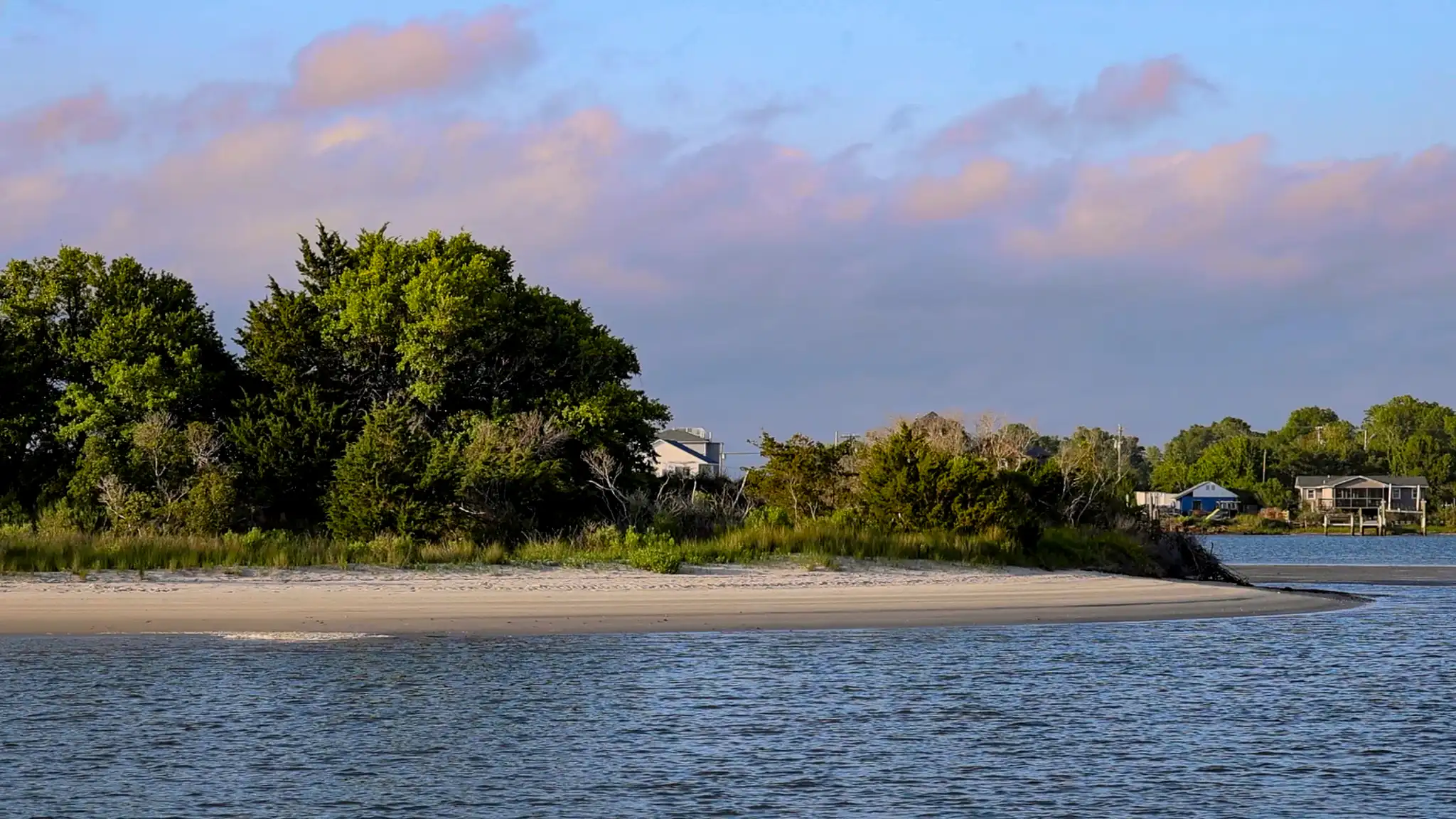 The sandy bank of Spoils Island, pink clouds in the sky.