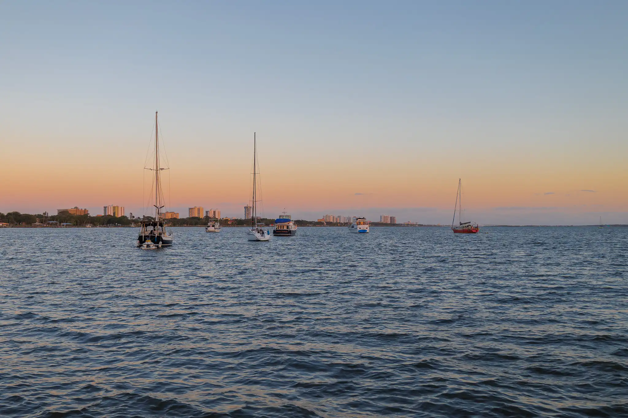 Sunset over Daytona Beach, six boats anchored at the Bethune Point Park anchorage.