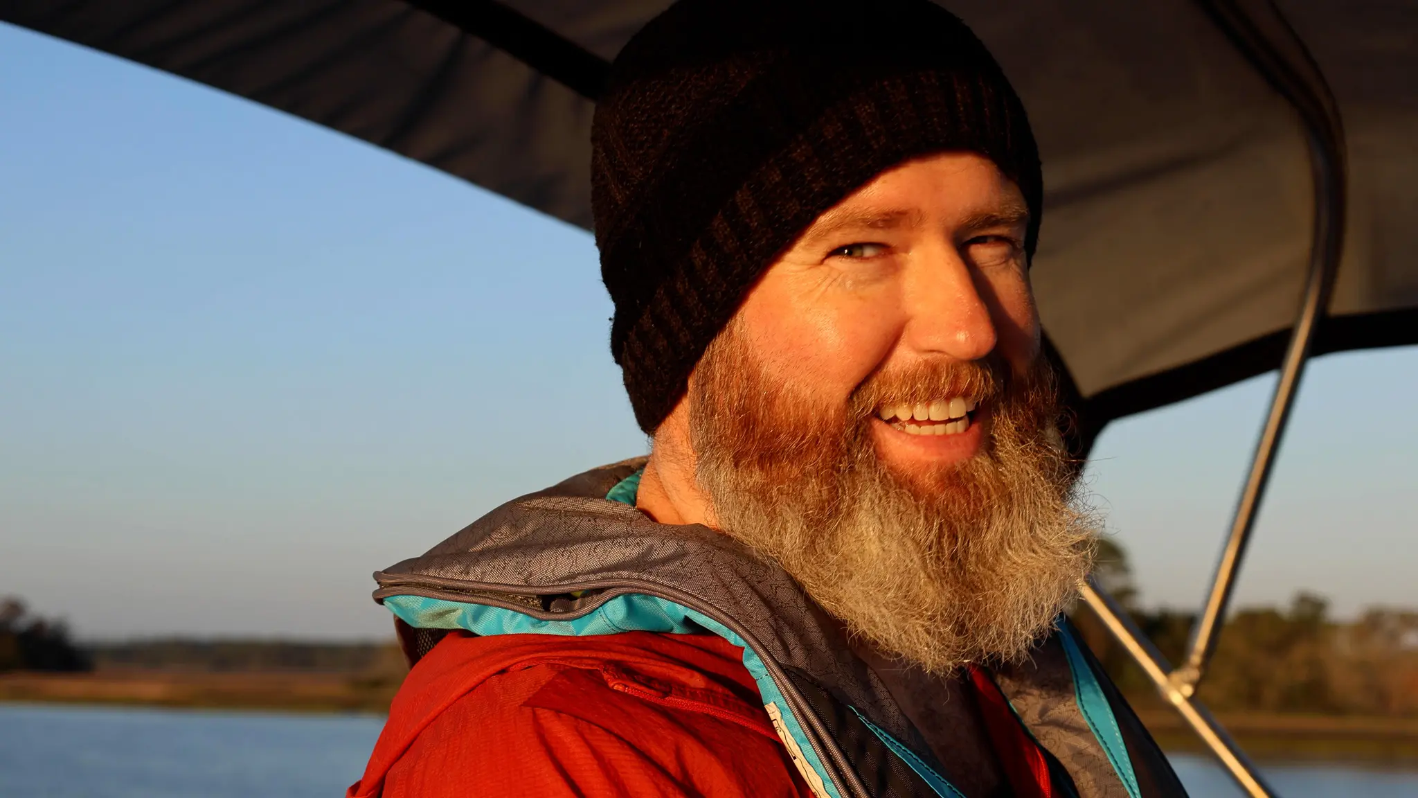 Captain Tom smiling while steering our Loop boat, Swamp Puppy.