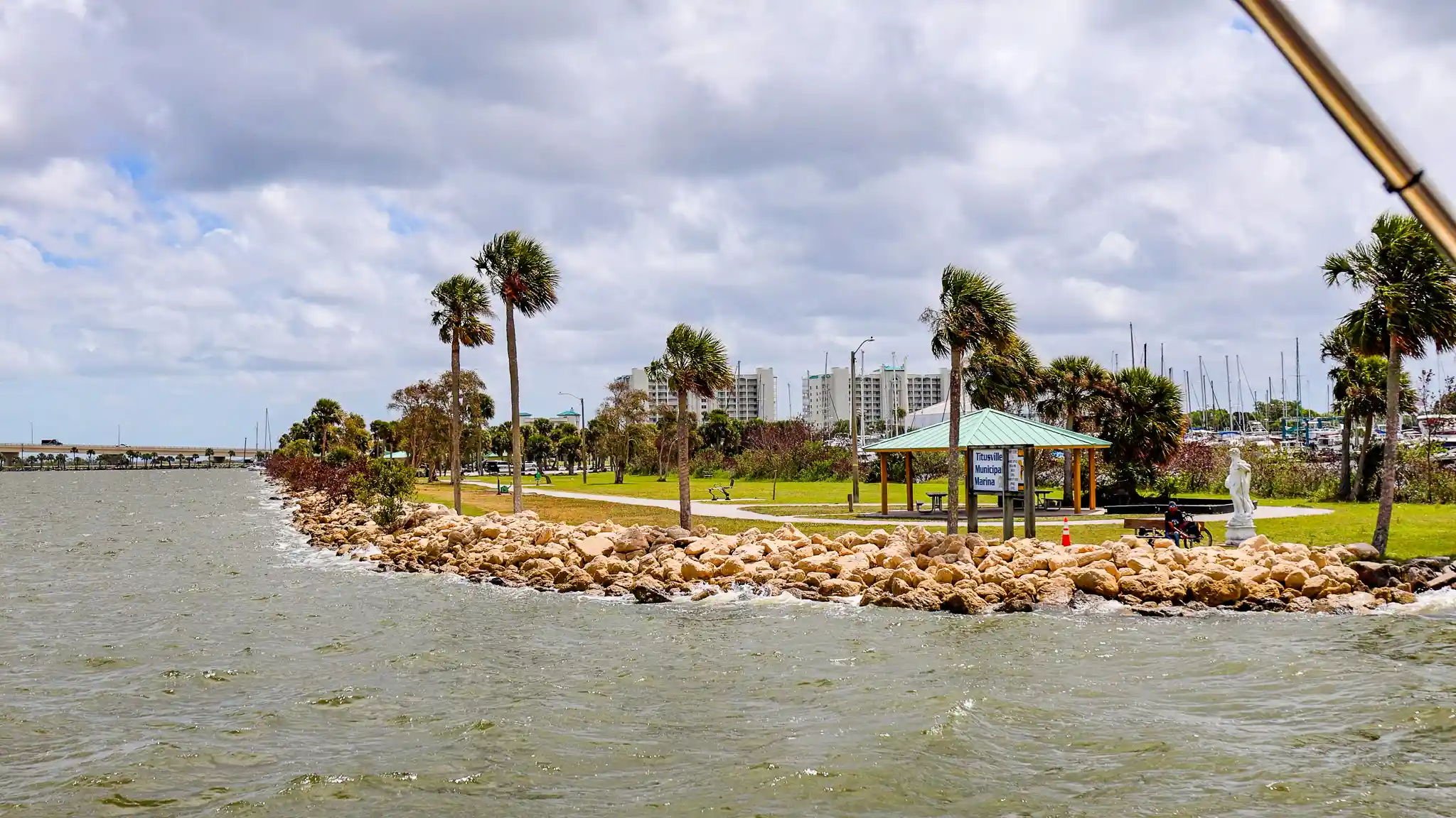 Titusville City Marina entrance with palm trees showing heavy winds.