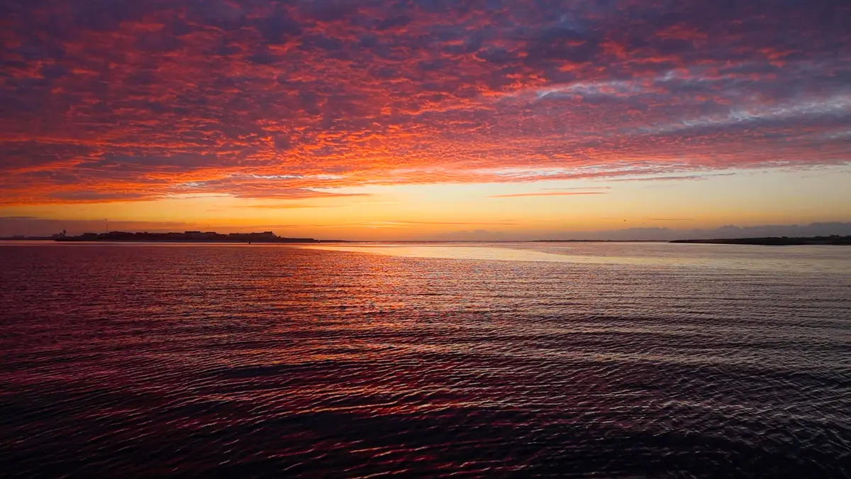 A vivid pink sunrise over Masonboro Inlet.